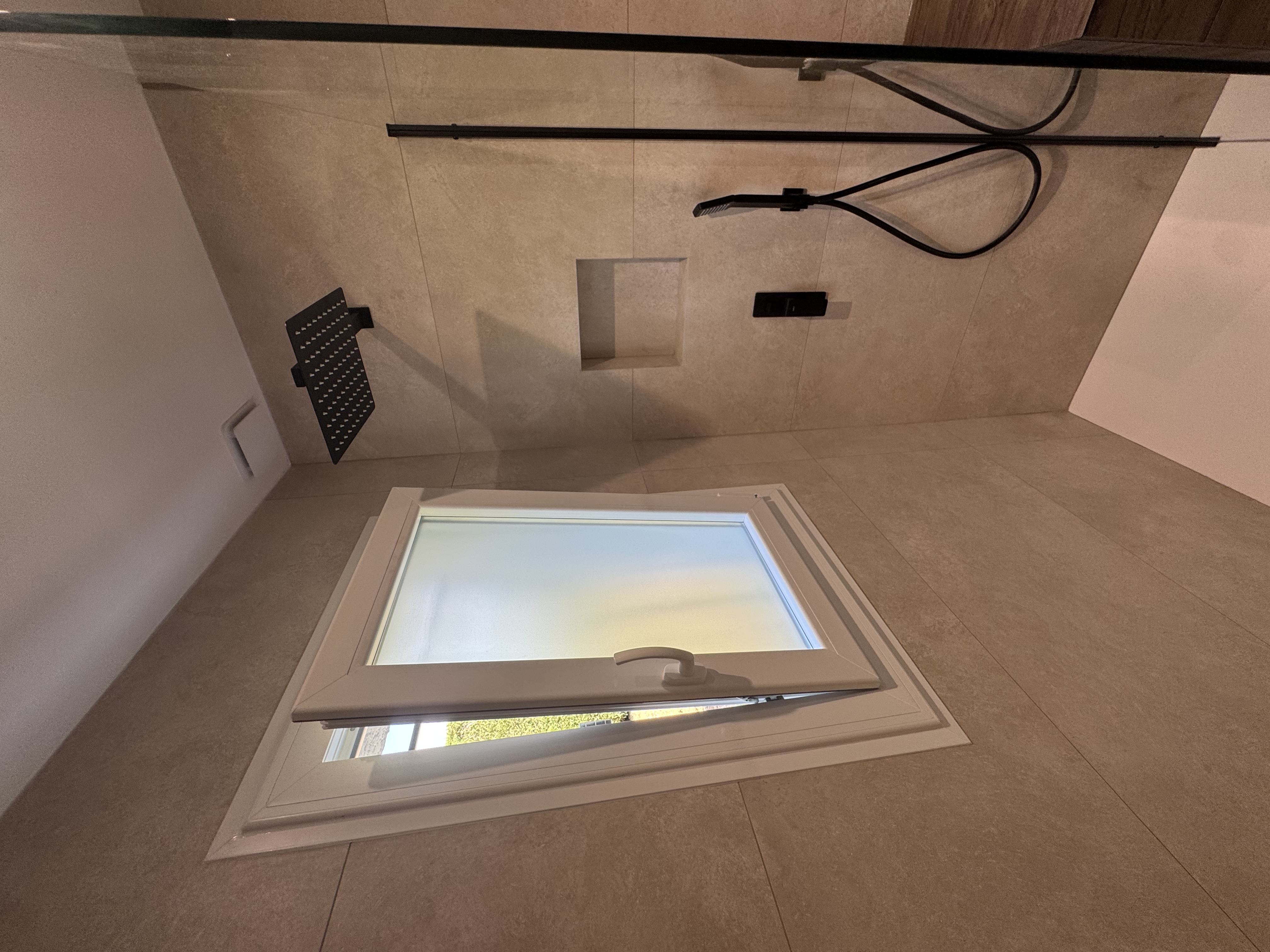 Douche à l'italienne, robinetterie noire et niche encastrée
